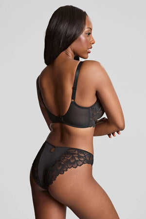 Woman wearing a black lace lingerie set on a plain background