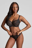 Woman wearing a black lace lingerie set against a plain background